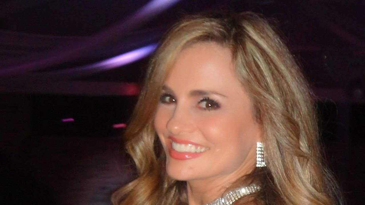 Aura Cristina Geithner sonríe a la cámara con un vestido rosa de pedrería y collar brillante durante la gala de los Premios Palmas de Oro 2014.
